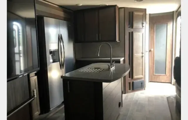 A kitchen with stainless steel appliances and a large island.