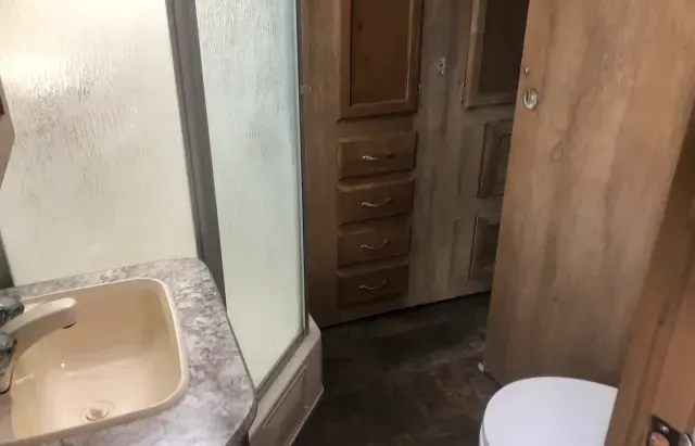 A bathroom with a sink , toilet and shower.