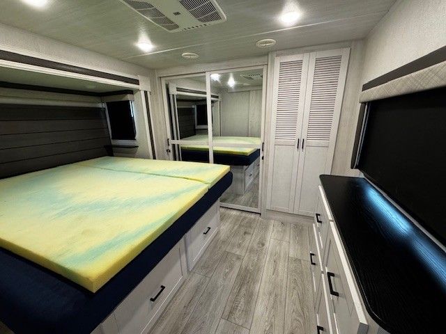 A bedroom with two beds and a dresser.