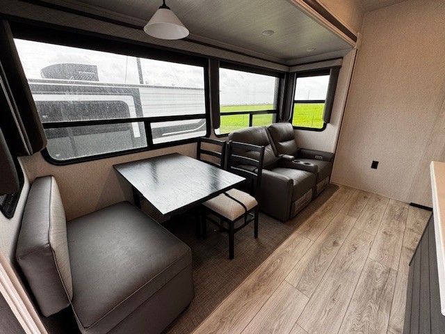 A living room in a trailer with a table and chairs.