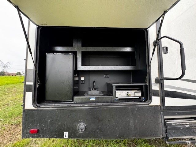 The back of a rv with the door open and a sink.
