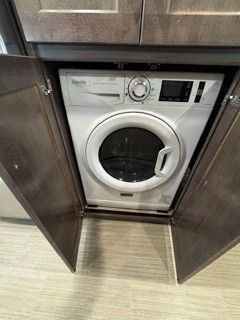A washer and dryer are built into a cabinet in a kitchen.