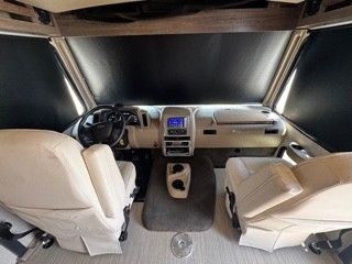 A large black and silver rv is parked in a parking lot.