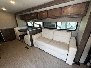 A rv with a couch and a table in the living room.