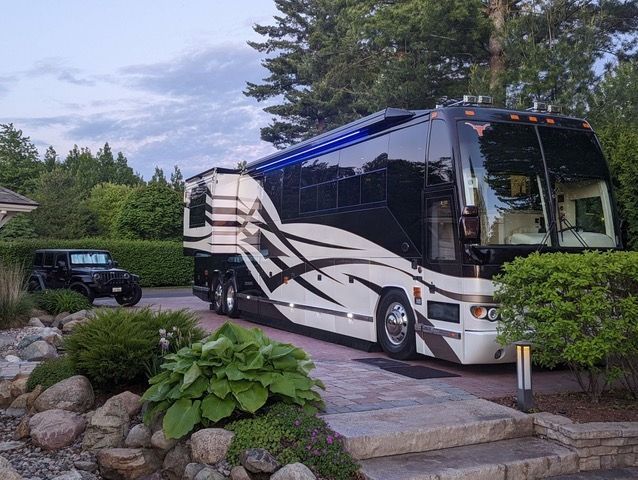 A large bus is parked in front of a house