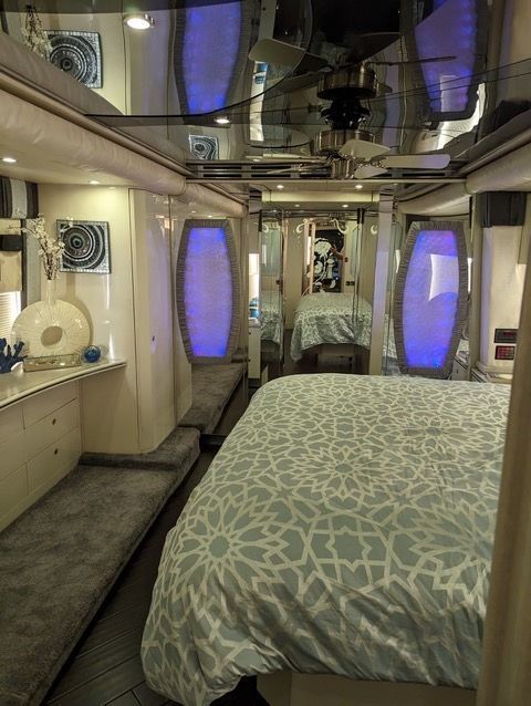 A bedroom with a bed and a mirrored ceiling