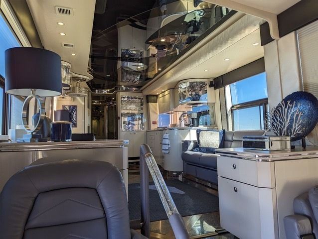 A living room with a couch , desk , chairs and lamps.