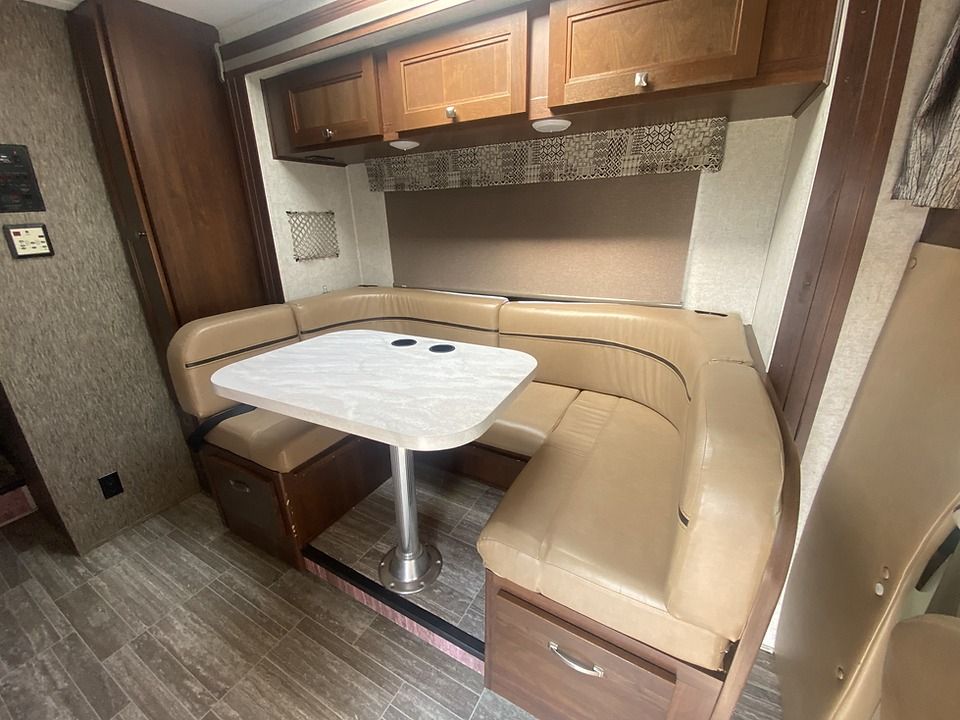 A rv with a table and a couch in it.