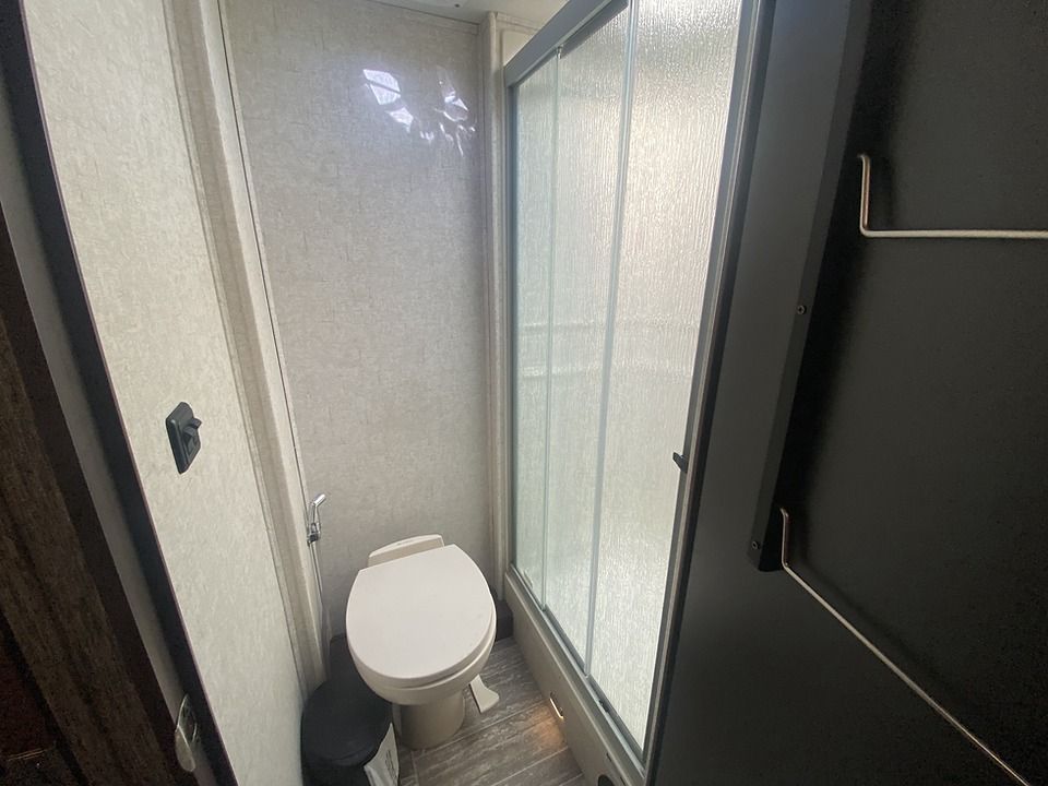 A bathroom with a toilet and a shower stall.