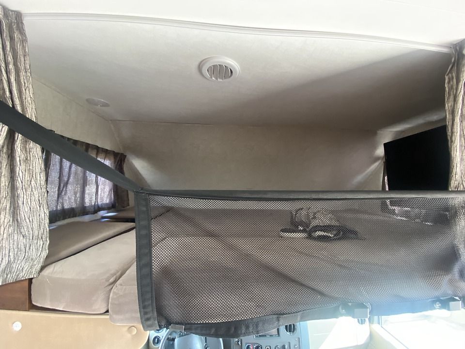 A bed in a camper with a mattress on top of it.