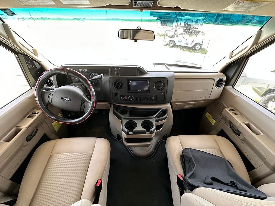 The interior of a van with a steering wheel and seats.