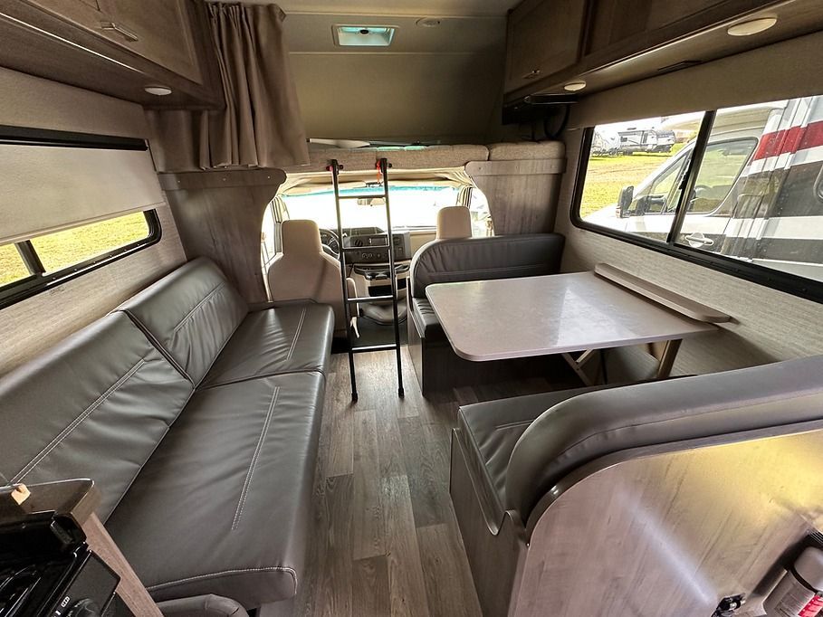 The inside of a rv with a table and couch.