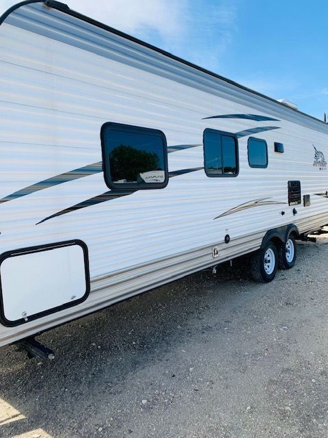 A white trailer is parked on the side of the road.