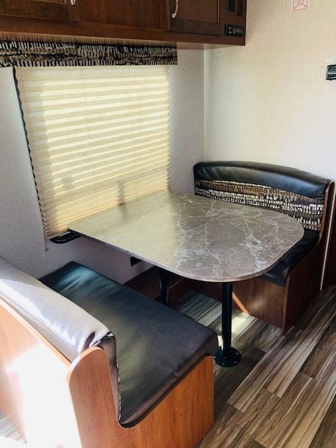 A dining area in a camper with a table and benches