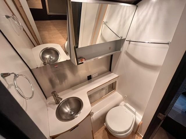 A bathroom with a sink , toilet and mirror.