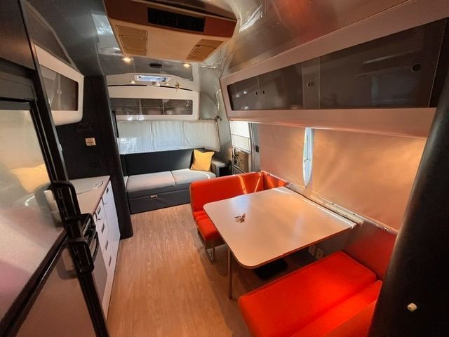 The inside of an airstream with a table and couch