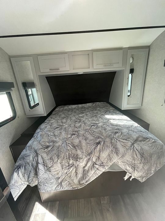 A bed is sitting in the middle of a trailer.