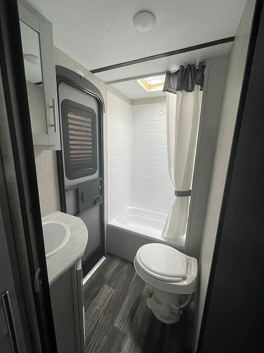A bathroom with a toilet , sink , shower and bathtub.
