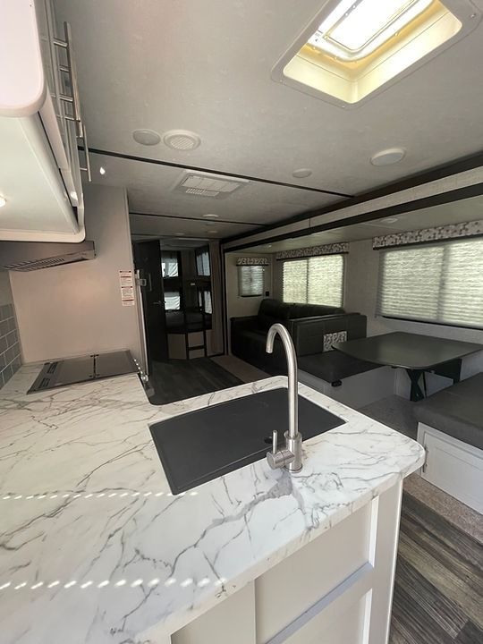 A kitchen with a sink and a table in a trailer.