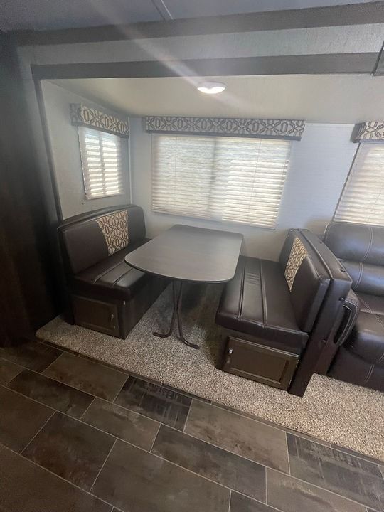 A living room with a table , couch , and benches.