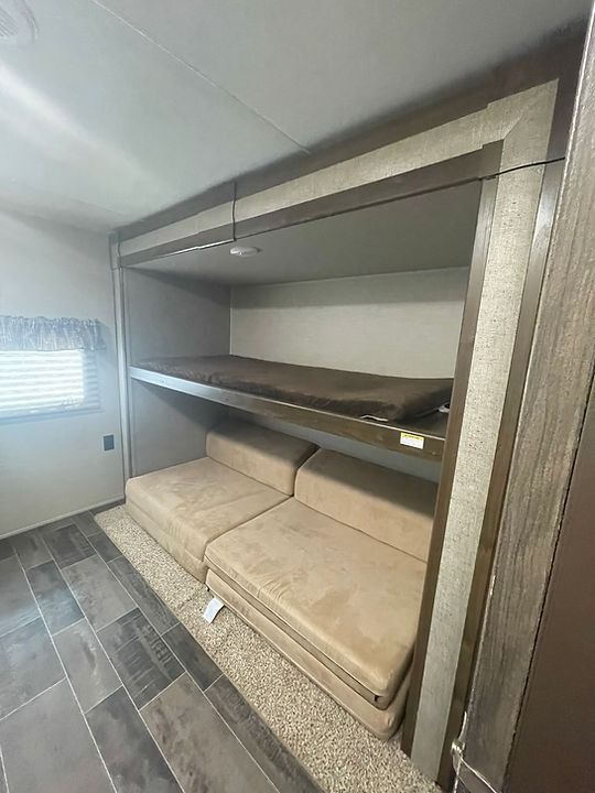 A room with bunk beds and a couch in it.