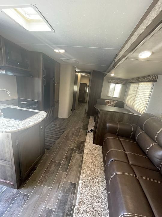 A rv with a couch and a kitchen in it.