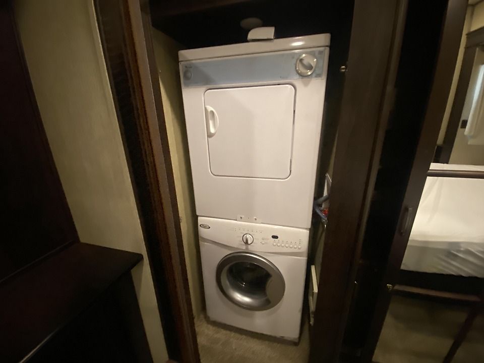 A washer and dryer are stacked on top of each other in a closet.