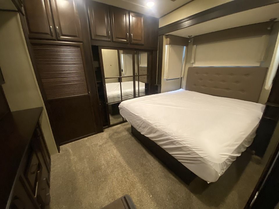 A bedroom with a king size bed and sliding glass doors.