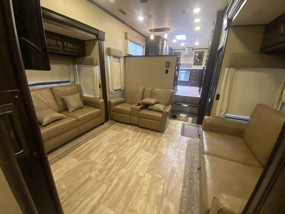 A living room with a couch and two chairs in a rv.
