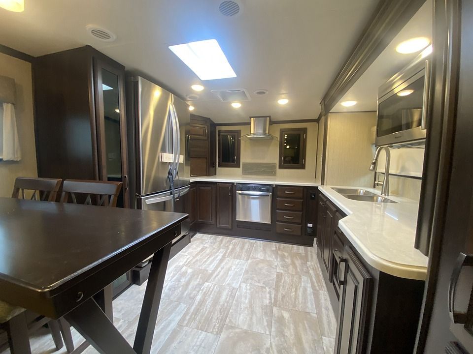 A kitchen with a table and chairs and stainless steel appliances