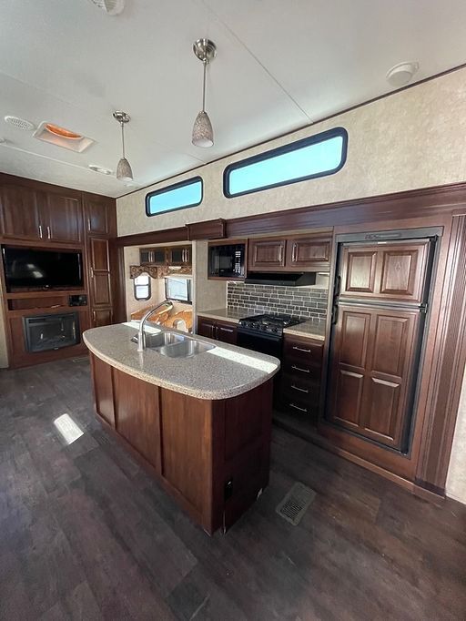 A kitchen in a rv with a large island in the middle.