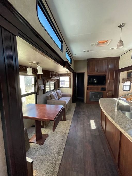 A living room in a trailer with a couch , table , and television.