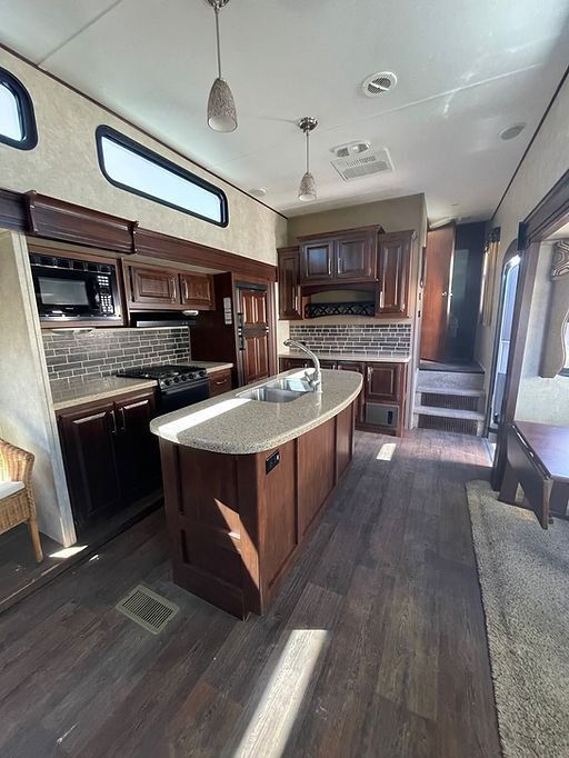 A kitchen in a mobile home with a large island in the middle.