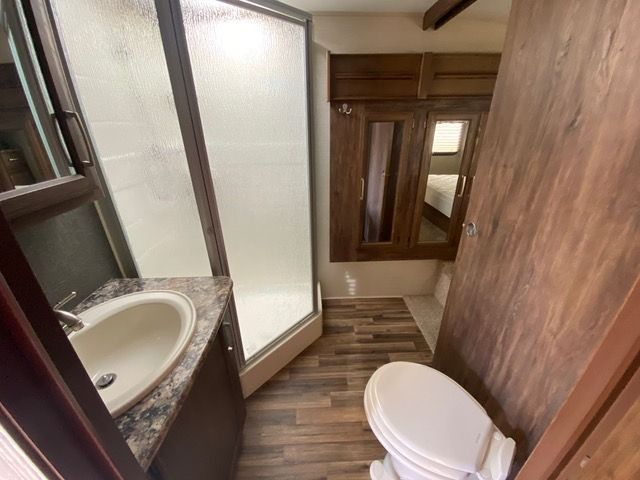 A bathroom with a toilet a sink and a shower