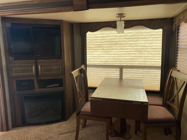 A living room with a table and chairs and a television