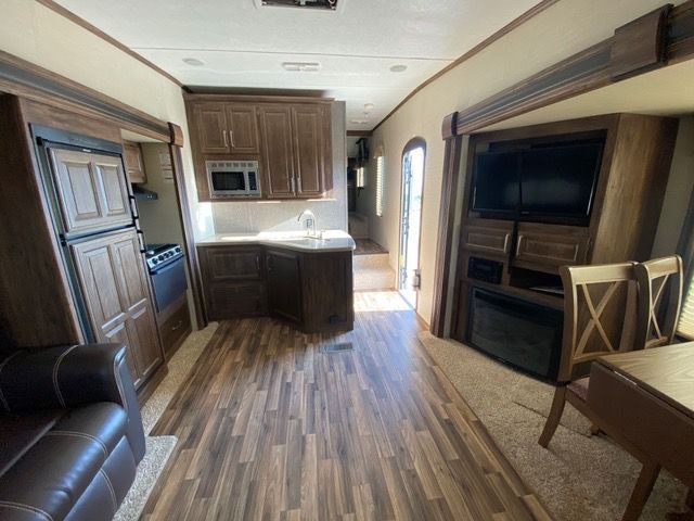 A living room with a couch , table and chairs in a mobile home.
