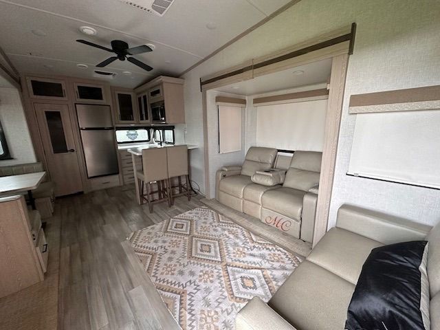 A living room in a rv with a couch and a rug.