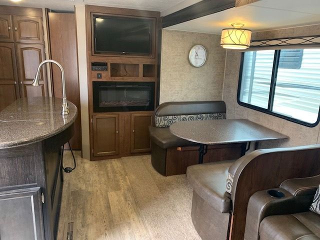 The inside of a rv with a table and chairs