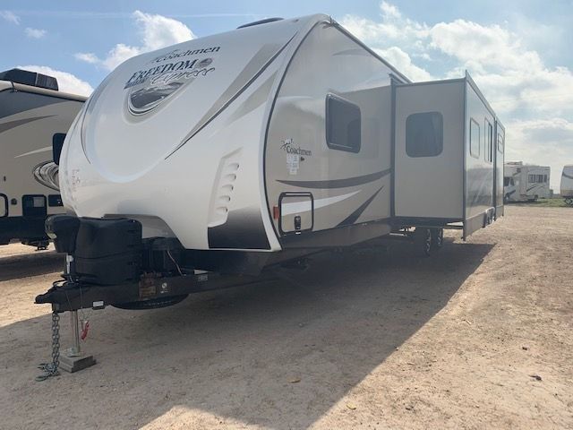 A white rv is parked in a dirt lot.