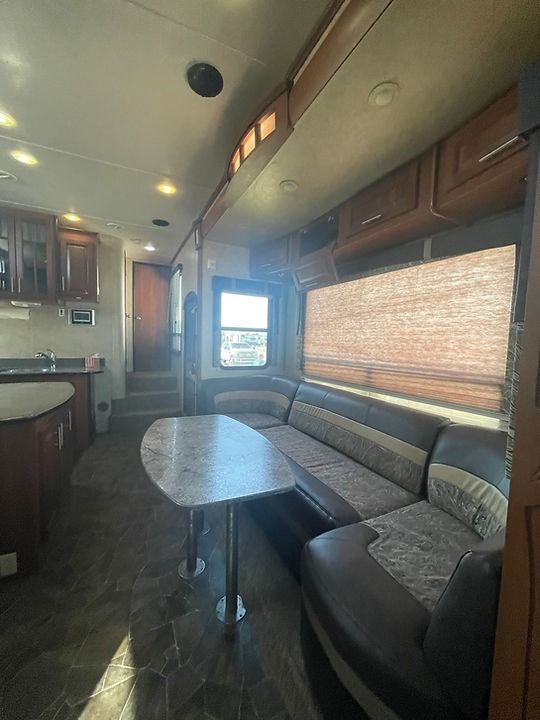 A living room in a rv with a couch and a table.