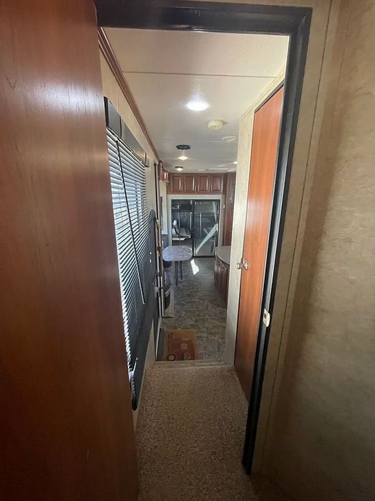 A hallway with a wooden door leading to a rv.