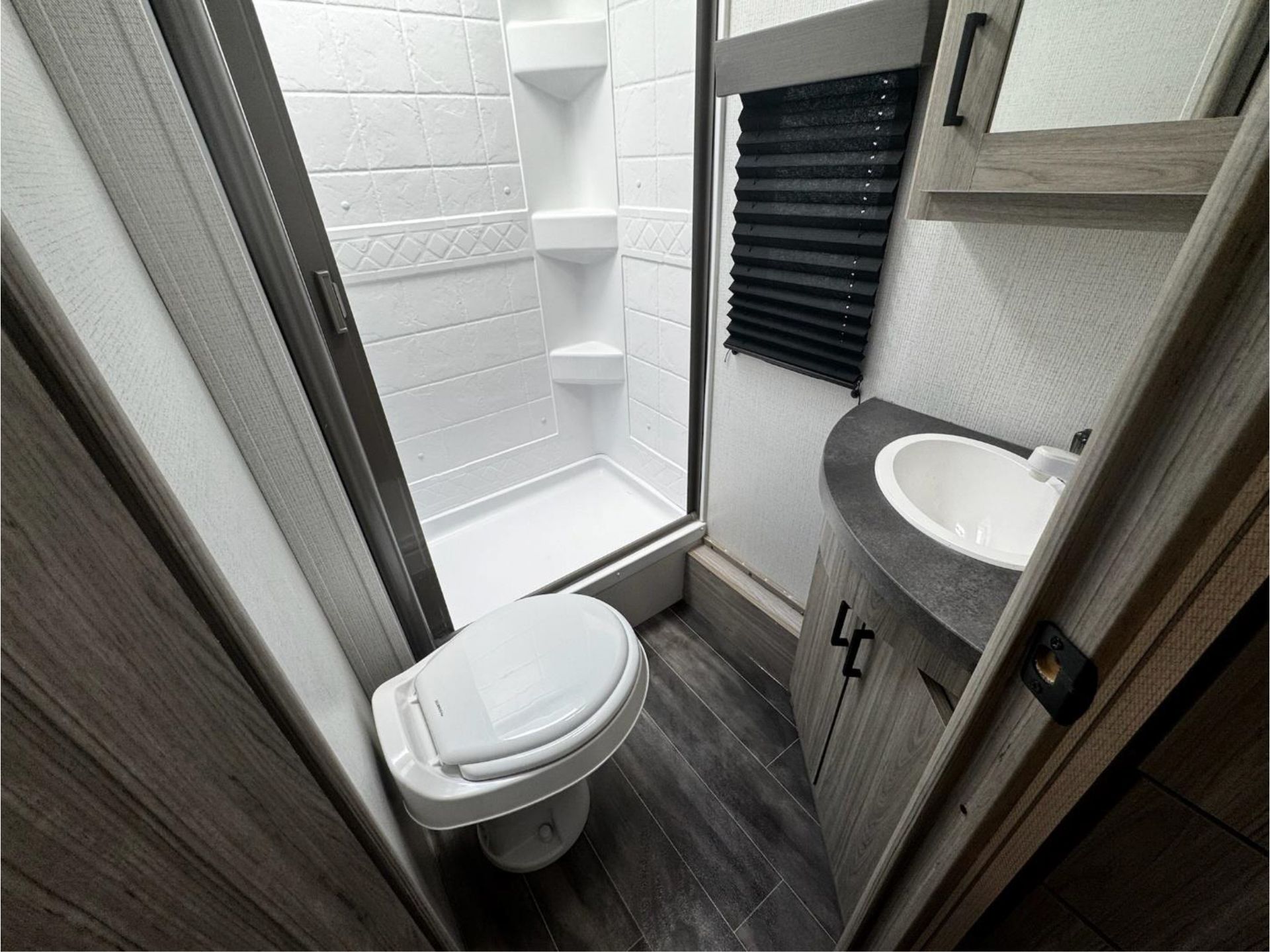 A bathroom with a toilet, sink, and shower