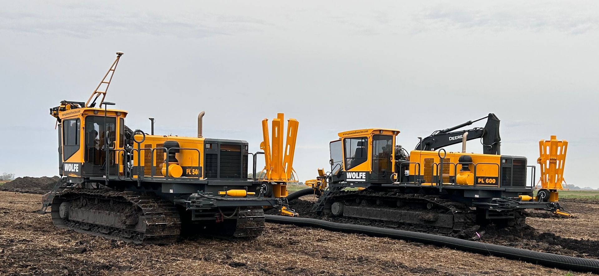 Two yellow tractors are sitting next to each other in a field.
