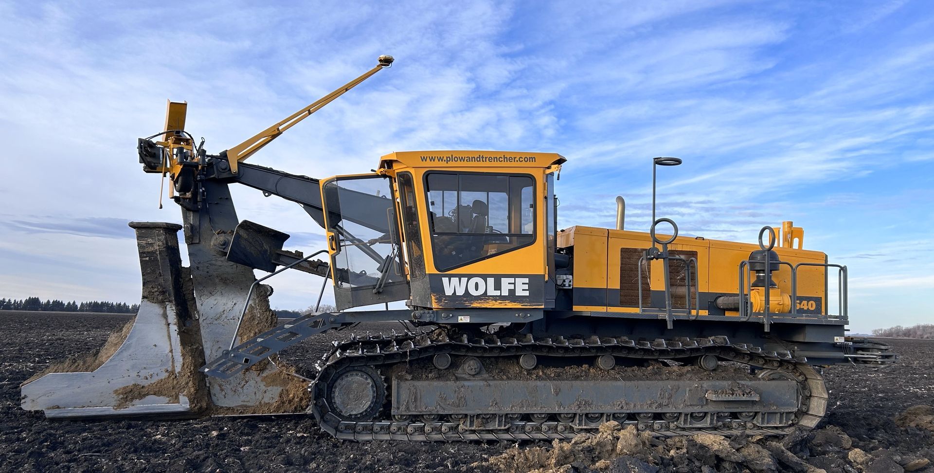 A yellow bulldozer is sitting in the middle of a dirt field.