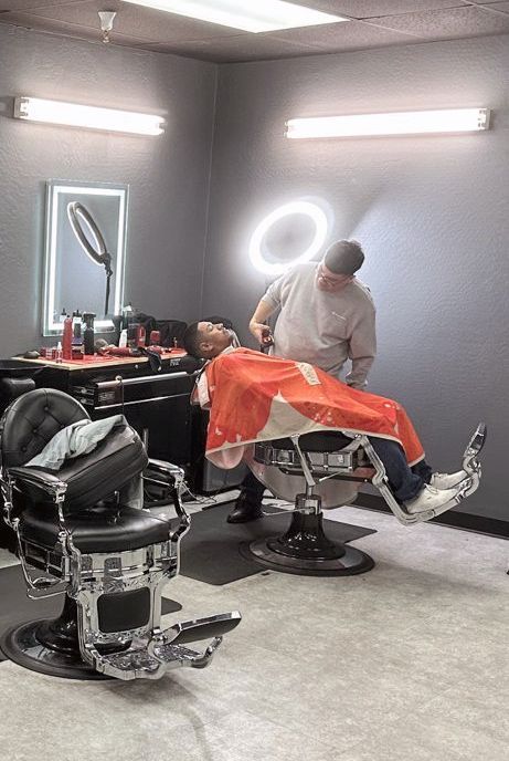 a man is getting his hair cut in a barber shop