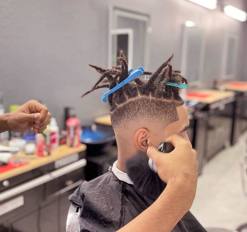 a man is getting his hair cut by a barber
