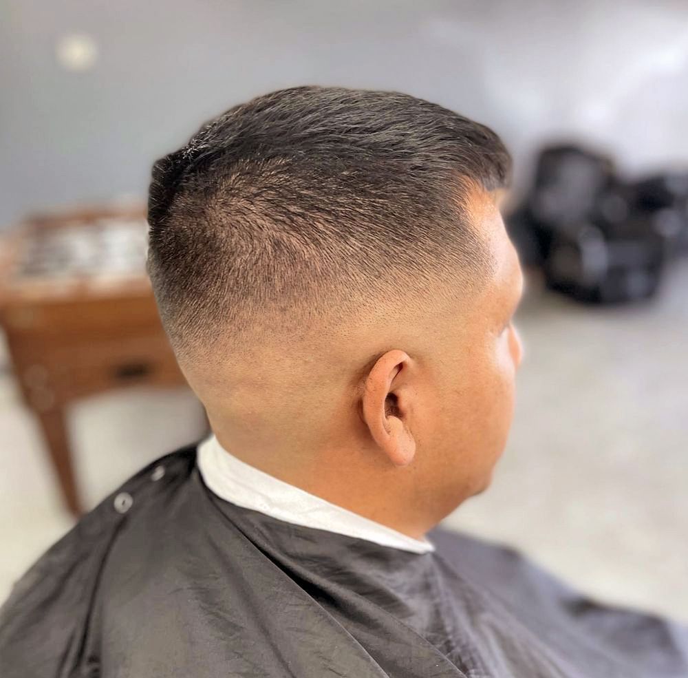 a man is getting his hair cut at a barber shop