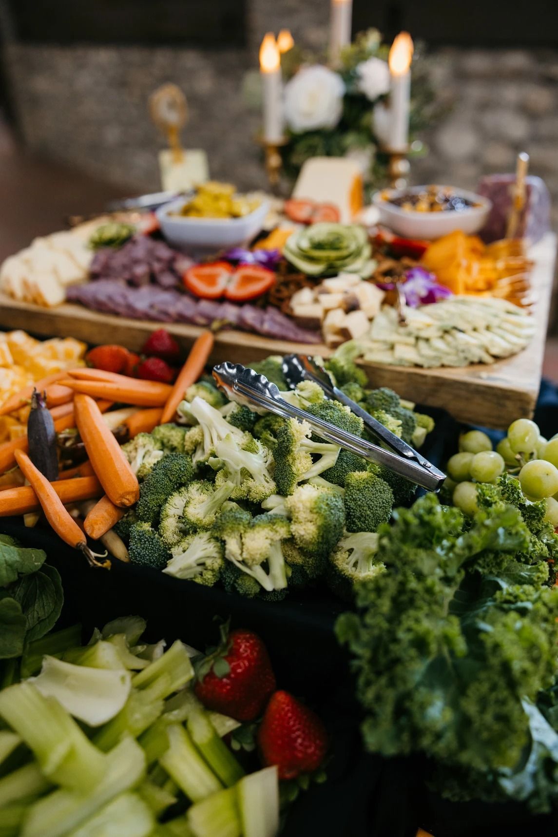 Fresh vegetable crudité platter with carrots, celery, broccoli, grapes, and dip in bowls