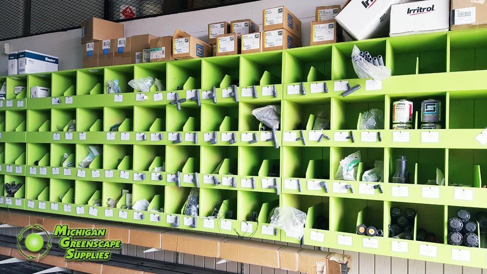 A bunch of green shelves with boxes on them