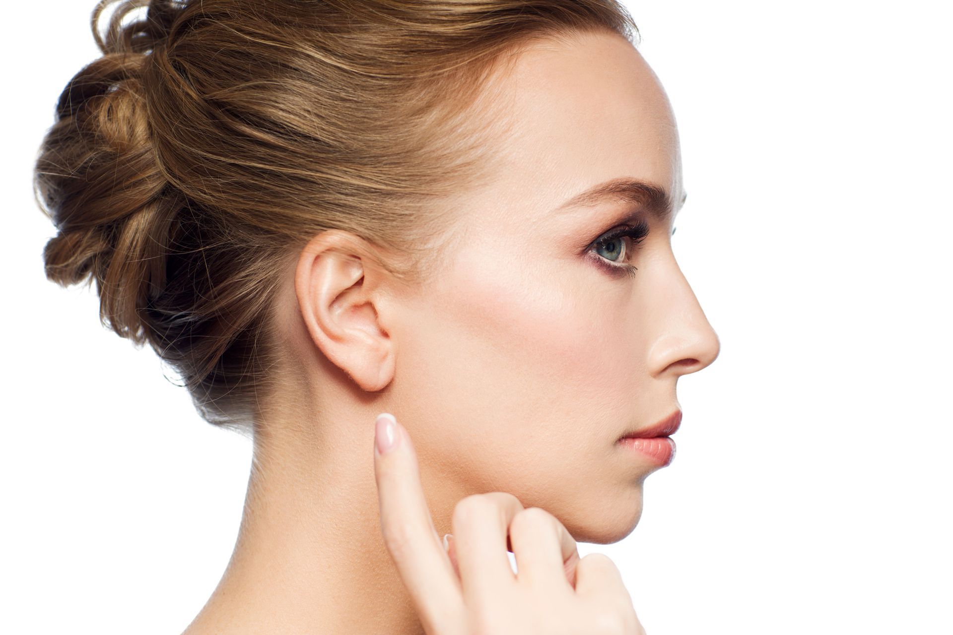Woman pointing to her ear, side profile. Blonde hair in updo, fair skin, white background.